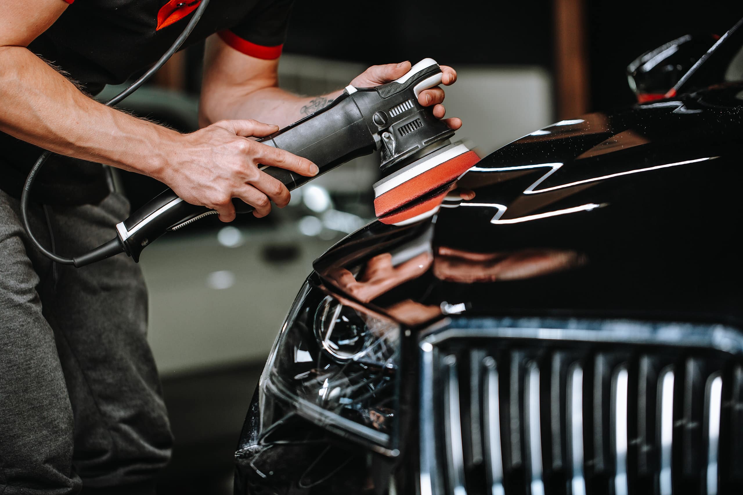 Professional detailing car in car studio, hands with orbital polisher, scratching remover, vehicle care concept