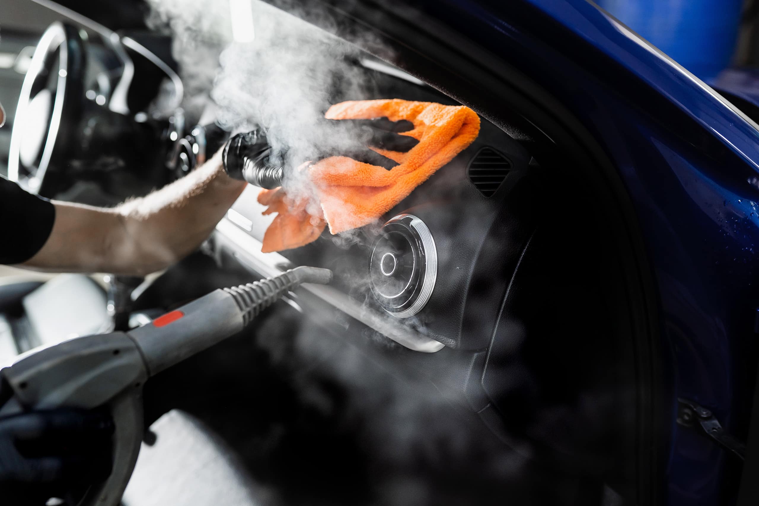 Steam cleaning of car air system. Worker in auto cleaning service clean car inside. Car interior detailing